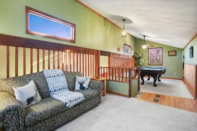 a living room with a couch and a piano at Hot tub, fireplace, fire pit, pool table, grill, EV, pets, HOA lake in Amanda