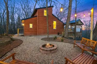 a log cabin with a fire pit in the yard at Hot tub, fireplace, fire pit, pool table, grill, EV, pets, HOA lake in Amanda