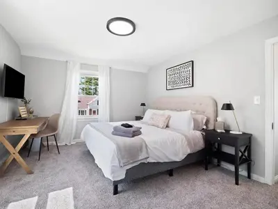a bedroom with a bed and a desk and a window at Home Away From Home - Beautiful Yard in South Euclid