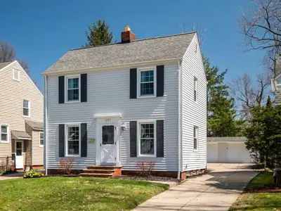 a white house with a black roof at Home Away From Home - Beautiful Yard in South Euclid