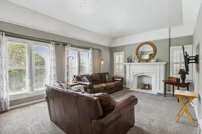a living room with a leather couch and a fireplace at Near CLE Clinic UH & Case Western in Shaker Heights
