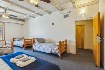 a room with two beds and a door to a bedroom at The Victor 2 - Cleveland's Urban Lodge in Cleveland