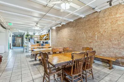 a dining room with a table and chairs and a brick wall at The Victor 2 - Cleveland's Urban Lodge in Cleveland
