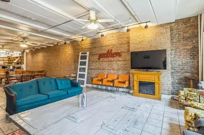 a living room with a blue couch and a fireplace at The Victor 2 - Cleveland's Urban Lodge in Cleveland