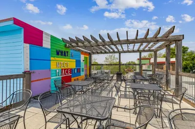 a patio with tables and chairs and a colorful wall at The Victor 2 - Cleveland's Urban Lodge in Cleveland