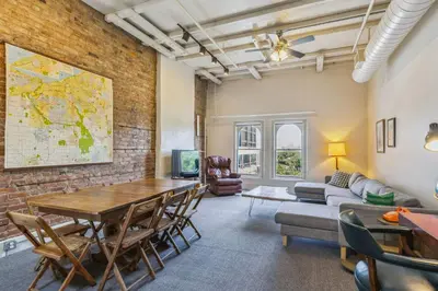 a living room with a brick wall and a table and chairs at The Victor 3 - Cleveland's Urban Lodge in Cleveland