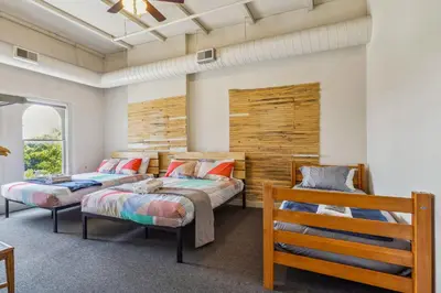 a bedroom with two beds and a bench at The Victor 3 - Cleveland's Urban Lodge in Cleveland
