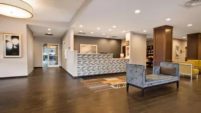 a lobby with two chairs and a bar at Best Western Plus Boardman Inn & Suites in Poland