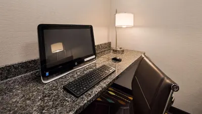 a desk with a computer monitor and a keyboard at Best Western Plus Boardman Inn & Suites in Poland