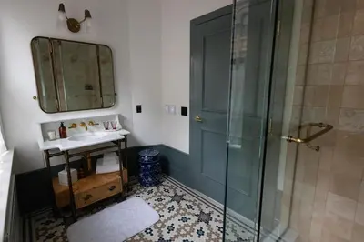 a bathroom with a shower and a sink and a mirror at Fidelity Hotel in Cleveland
