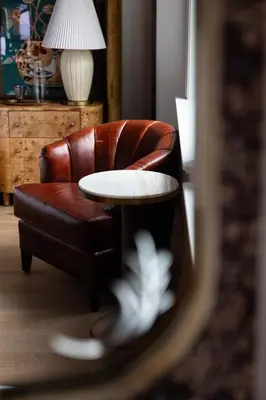 a brown leather chair with a white table in a living room at Fidelity Hotel in Cleveland