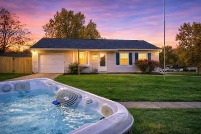 a hot tub in a yard in front of a house at Private Ranch - Entire Home - 3 Bed Room - Hot Tub - King Bed - Fenced Yard - Pets & Kids Welcome - Game Shed - Free WiFi in Columbus