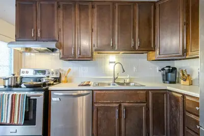 a kitchen with wooden cabinets and a sink at Private Ranch - Entire Home - 3 Bed Room - Hot Tub - King Bed - Fenced Yard - Pets & Kids Welcome - Game Shed - Free WiFi in Columbus