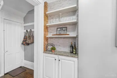 a kitchen with white cabinets and a counter with wine bottles at The Beer Baron House - Rhinegeist - FREE Streetcar in Cincinnati