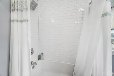 a white bath tub with a shower curtain in a bathroom at The Beer Baron House - Rhinegeist - FREE Streetcar in Cincinnati