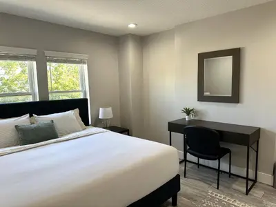 a bedroom with a bed and a desk and a mirror at Charming 2BR Near Downtown & Attractions in Columbus