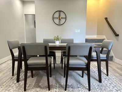 a dining room table with chairs and a clock on the wall at Charming 2BR Near Downtown & Attractions in Columbus