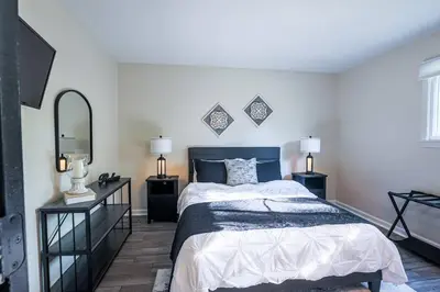 a bedroom with a bed and two night stands and a mirror at Rocky river Escape in Cleveland