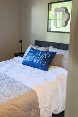 a bed with a blue pillow on top of it at Rocky river Escape in Cleveland