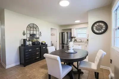 a kitchen with a table and chairs and a clock on the wall at Rocky river Escape in Cleveland