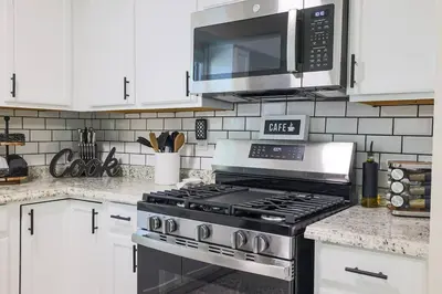 a kitchen with a stove and a microwave at Rocky river Escape in Cleveland