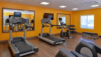 a gym with treadmills and ellipticals in a room at Holiday Inn Express & Suites Lexington Midtown - I-75 by IHG in Lexington