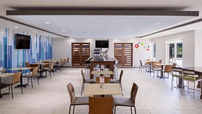 a dining room with tables and chairs in a restaurant at Holiday Inn Express & Suites Lexington Midtown - I-75 by IHG in Lexington