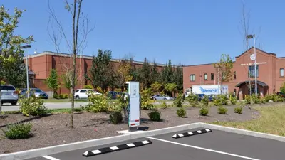 a parking lot with a parking meter in front of a building at Holiday Inn Express & Suites Lexington Midtown - I-75 by IHG in Lexington