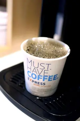 a cup of coffee sitting on top of a table at Holiday Inn Express & Suites New Martinsville by IHG in New Martinsville