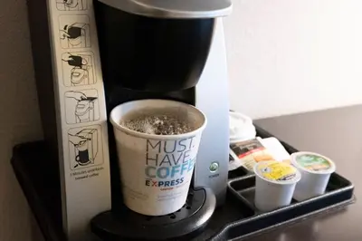 a coffee maker with a cup of coffee on a shelf at Holiday Inn Express & Suites New Martinsville by IHG in New Martinsville
