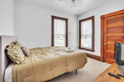 a bedroom with a bed and a flat screen tv at Cozy Renovated 19th Century Home, 5 Min to OSU! in Columbus