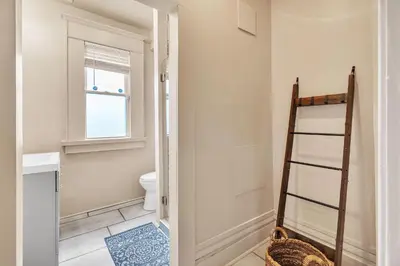 a bathroom with a toilet and a ladder at Cozy Renovated 19th Century Home, 5 Min to OSU! in Columbus