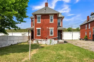 an old red brick house with a roof at Cozy Renovated 19th Century Home, 5 Min to OSU! in Columbus