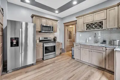 a kitchen with wooden cabinets and stainless steel appliances at Cozy Renovated 19th Century Home, 5 Min to OSU! in Columbus