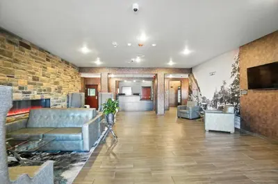 a lobby with couches and a television in a building at Cobblestone Hotel & Suites - Bellefontaine in Bellefontaine