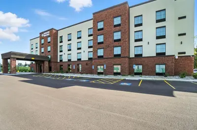 an empty parking lot in front of a building at Cobblestone Hotel & Suites - Bellefontaine in Bellefontaine