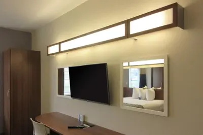 a hotel room with a mirror and a bed at Quality Inn & Suites Caldwell I-77 in Caldwell