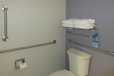 a bathroom with a toilet and towels on the wall at Quality Inn & Suites Caldwell I-77 in Caldwell