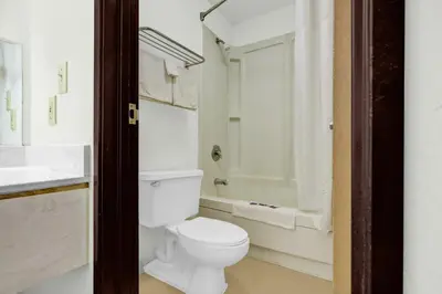 a bathroom with a white toilet and a shower at Brookville Inn By OYO Near Dayton International Airport in Brookville
