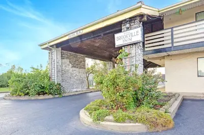 a building with a sign for a parking lot at Brookville Inn By OYO Near Dayton International Airport in Brookville