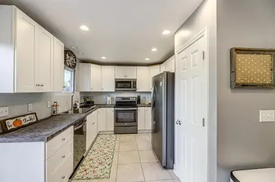 a kitchen with white cabinets and a stainless steel refrigerator at half Mi to Creation Museum Home with Large Yard! in Petersburg