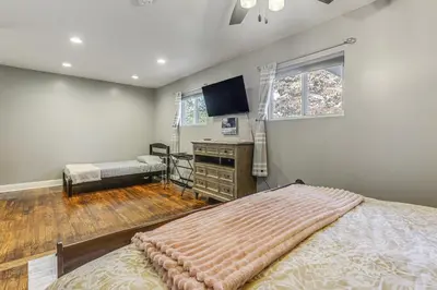 a bedroom with a bed and a dresser and a television at half Mi to Creation Museum Home with Large Yard! in Petersburg