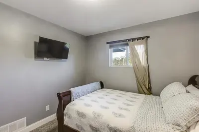 a bedroom with a bed and a tv on the wall at half Mi to Creation Museum Home with Large Yard! in Petersburg