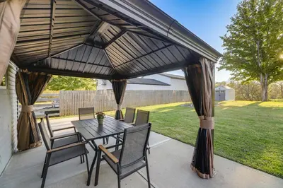 a patio with a table and chairs under awning at half Mi to Creation Museum Home with Large Yard! in Petersburg