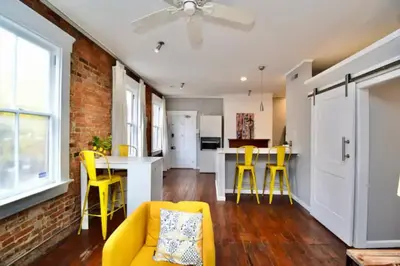 a living room with a yellow couch and yellow chairs at Walk to Everything - Sports, Food, Music, Downtown in Cincinnati