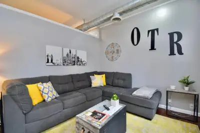 a living room with a gray couch and yellow pillows at Walk to Everything - Sports, Food, Music, Downtown in Cincinnati