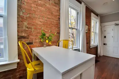 a kitchen with a white table and yellow chairs at Walk to Everything - Sports, Food, Music, Downtown in Cincinnati