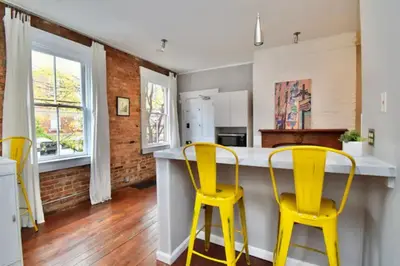 a kitchen with two yellow chairs at a counter at Walk to Everything - Sports, Food, Music, Downtown in Cincinnati