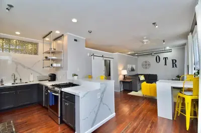 a kitchen with white counters and a kitchen with yellow chairs at Walk to Everything - Sports, Food, Music, Downtown in Cincinnati