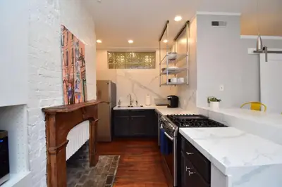 a kitchen with white walls and a white brick wall at Walk to Everything - Sports, Food, Music, Downtown in Cincinnati